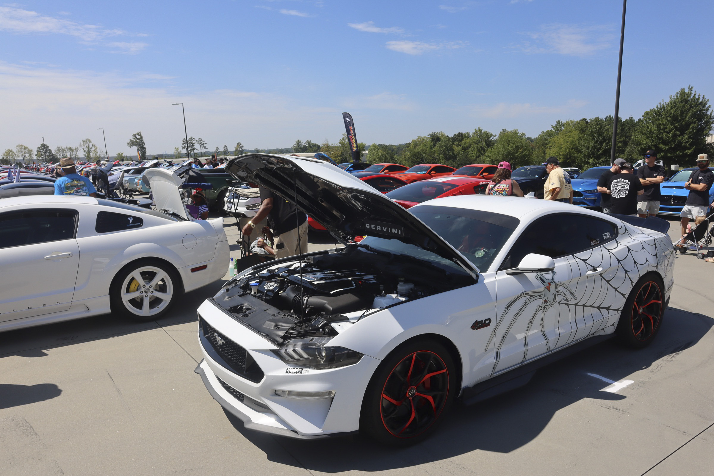White Ford Mustang with custom decals at Mustang Week event.