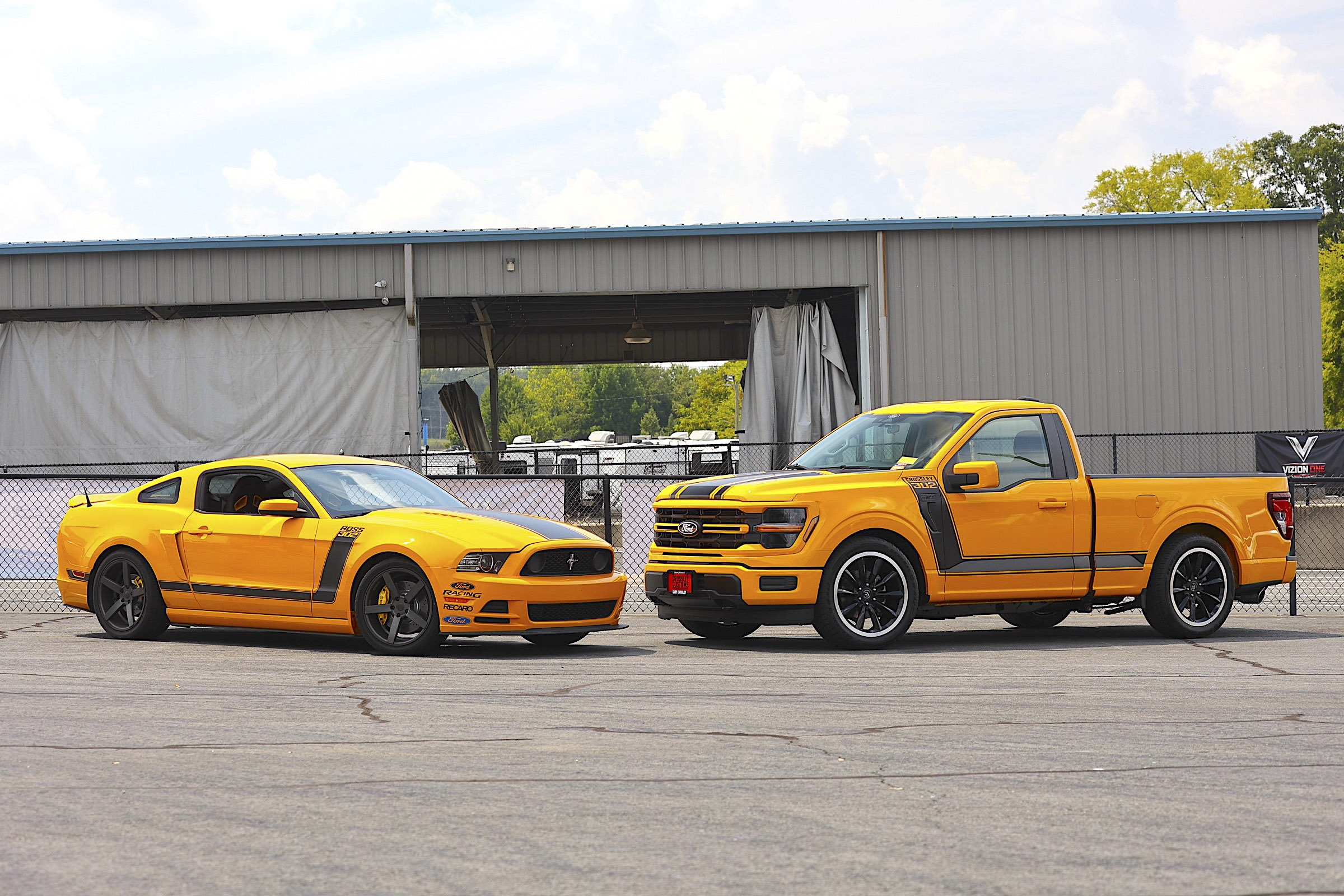 Yellow Ford Mustang and pickup truck at Mustang Week 2026 event.