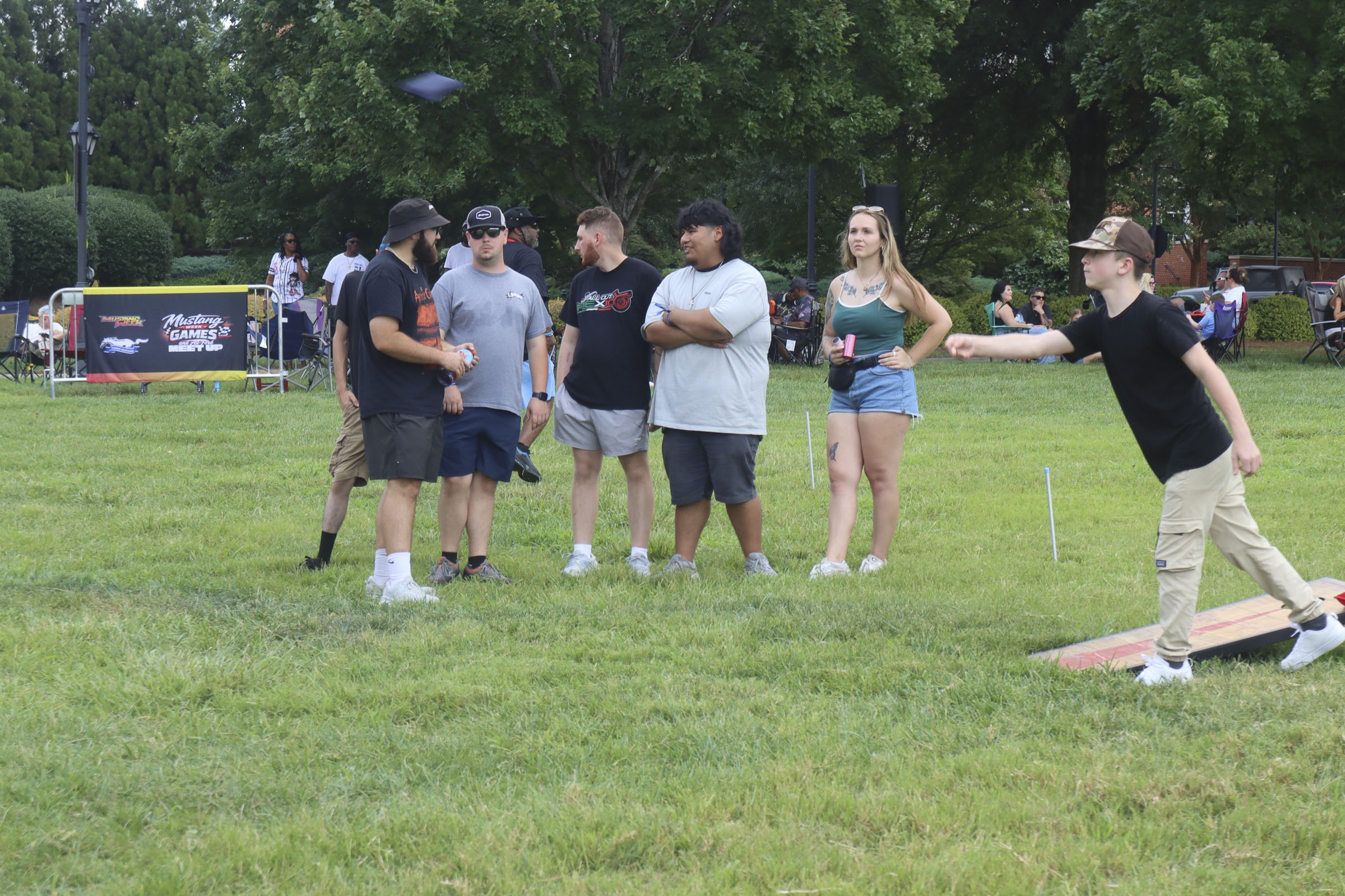 Group of people playing cornhole at Mustang Week event in Charlotte 2026.