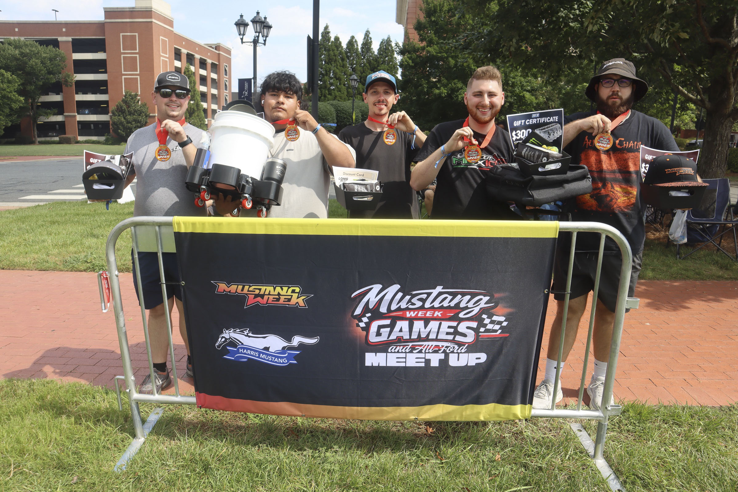 Group of people at Mustang Week event with cars and banners in Charlotte 2026.