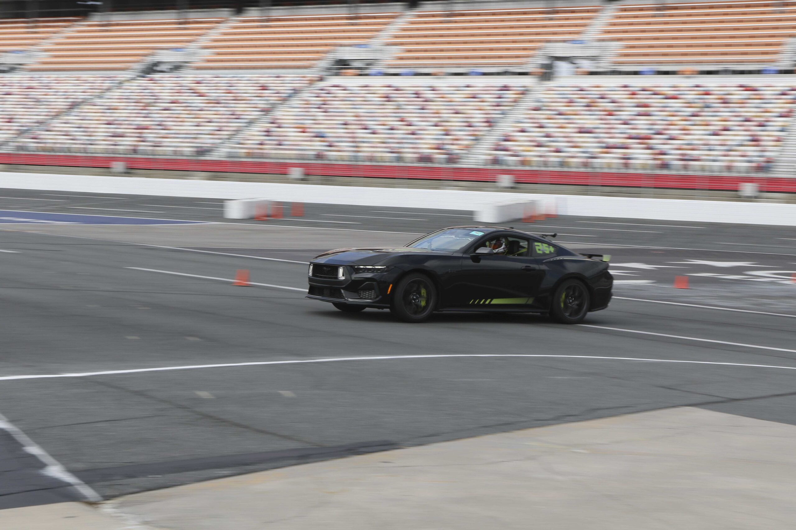 Black Ford Mustang on race track during Mustang Week event.