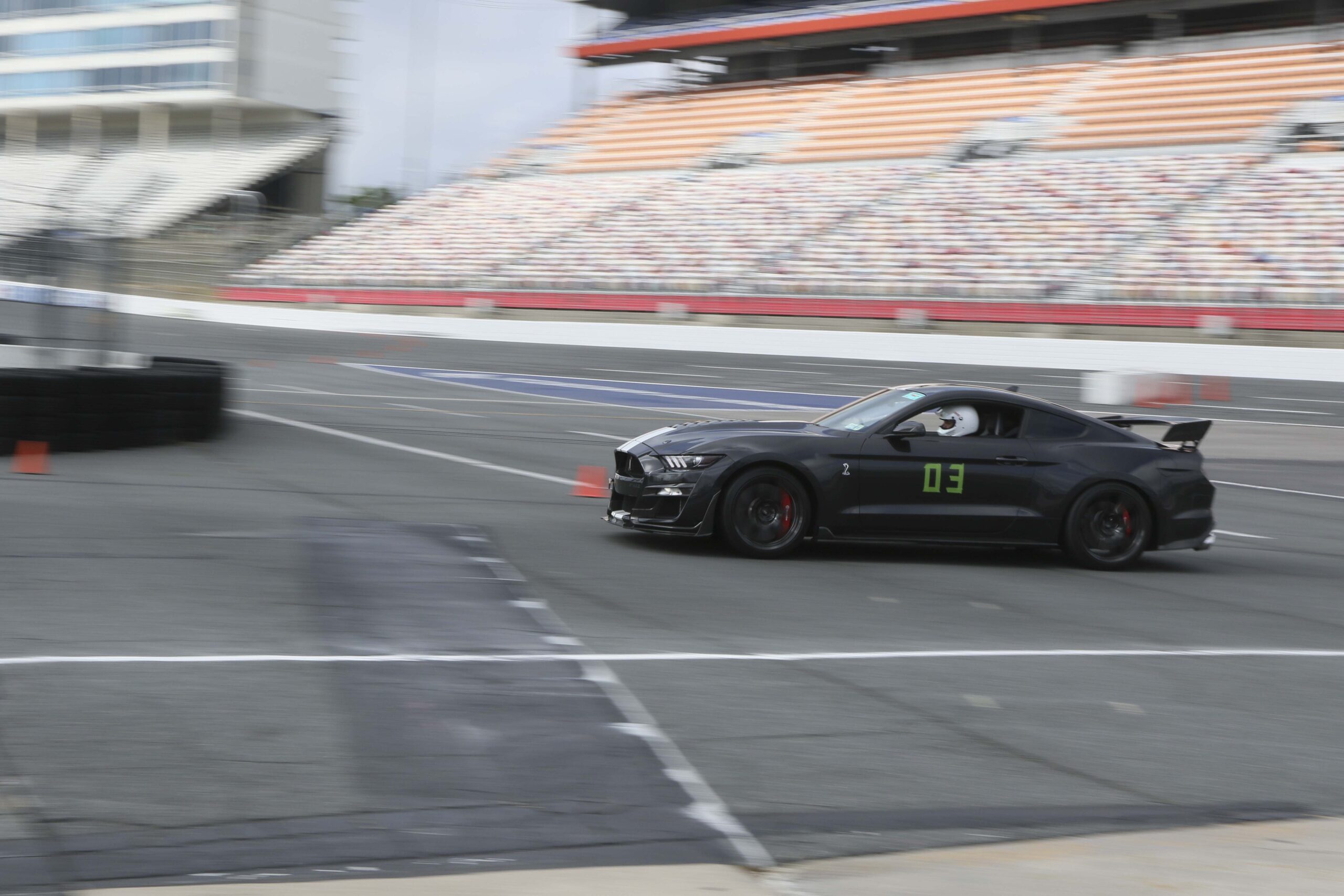 Black Mustang race car on track at Charlotte 2026 with number 03.
