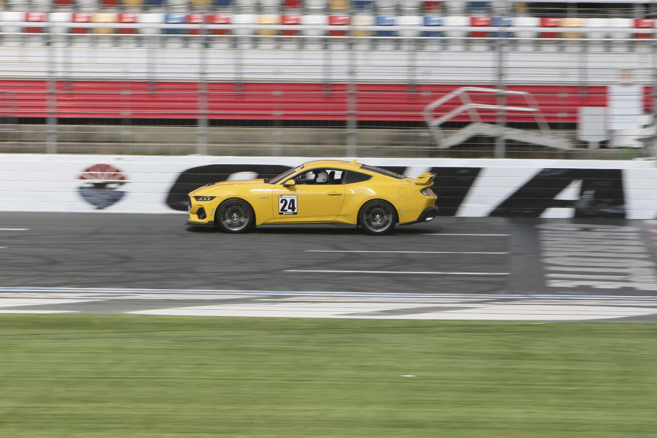 Yellow Ford Mustang race car on track at Charlotte 2026 event.