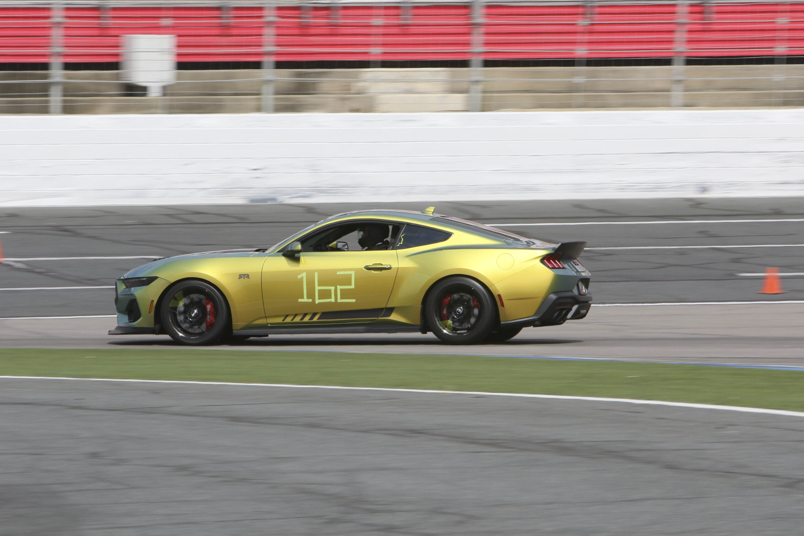 Yellow Mustang race car on track at Charlotte 2026 event.