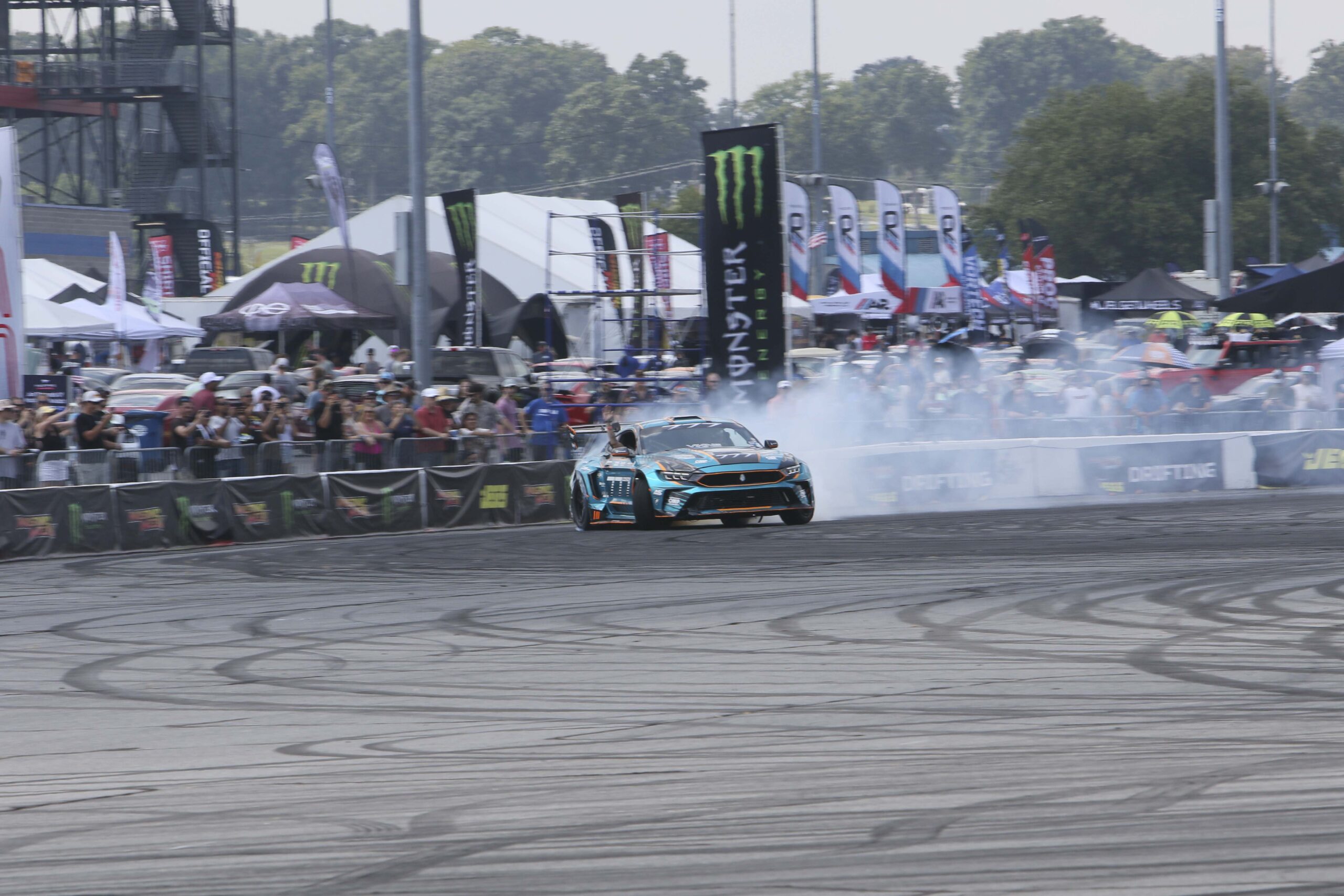 High-speed drift car performing stunts at Mustang Week event.