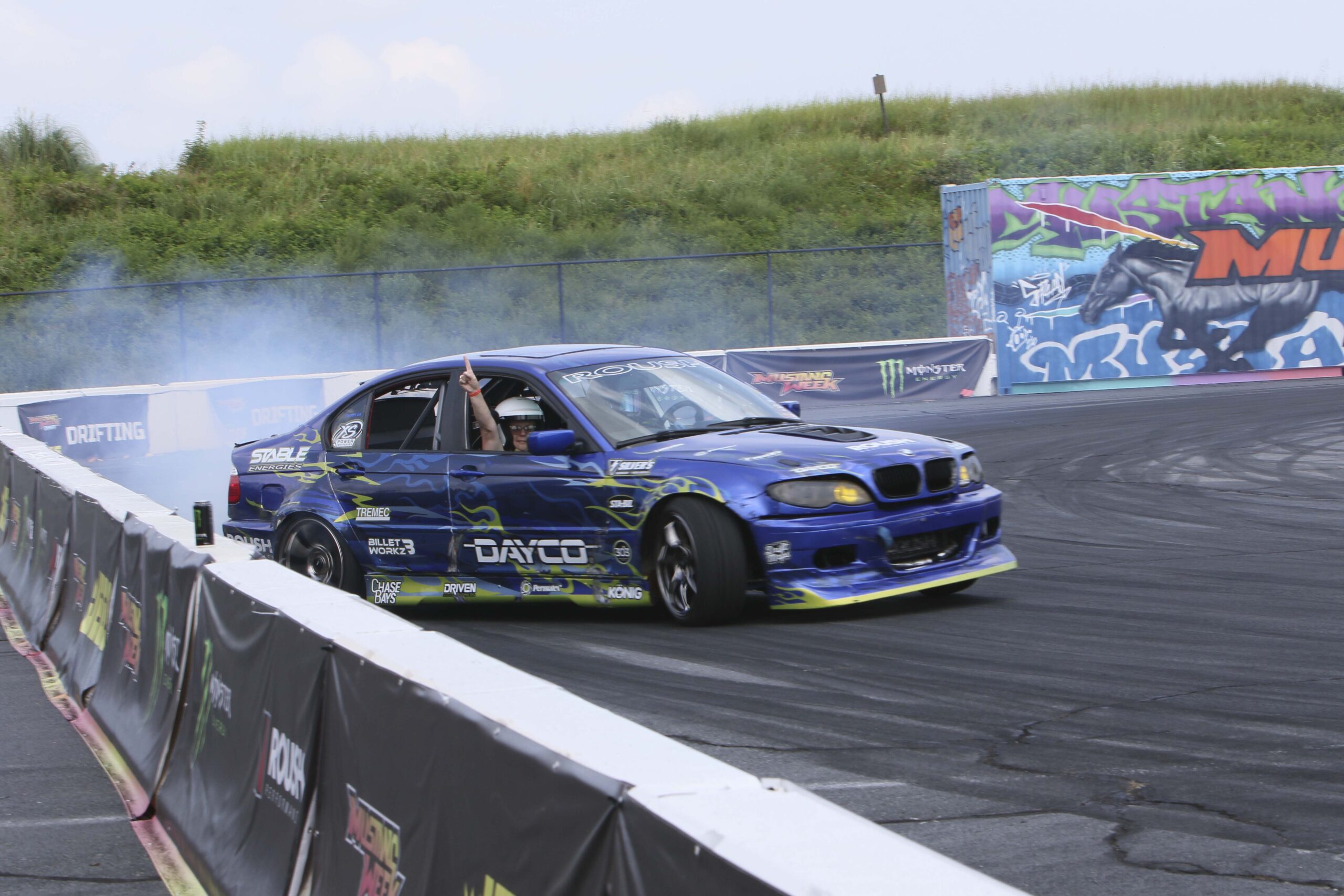 Blue drift car performing a burnout at Mustang Week event in Charlotte 2026.