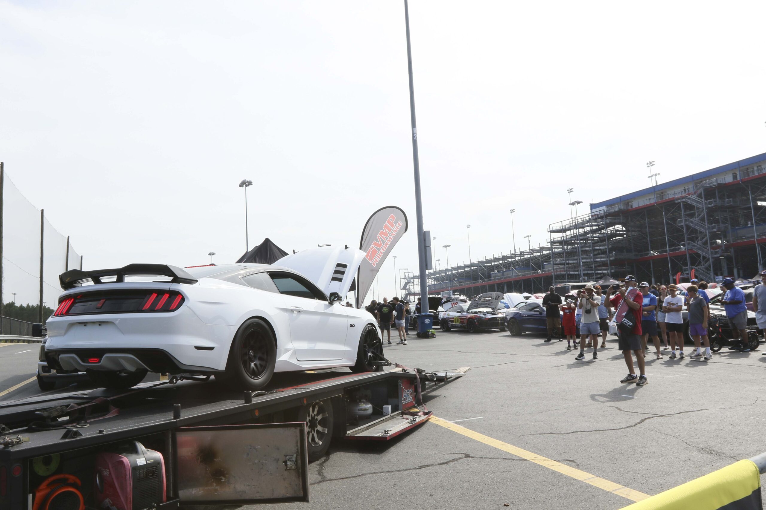 White sports car on trailer at Mustang Week event in Charlotte 2026.