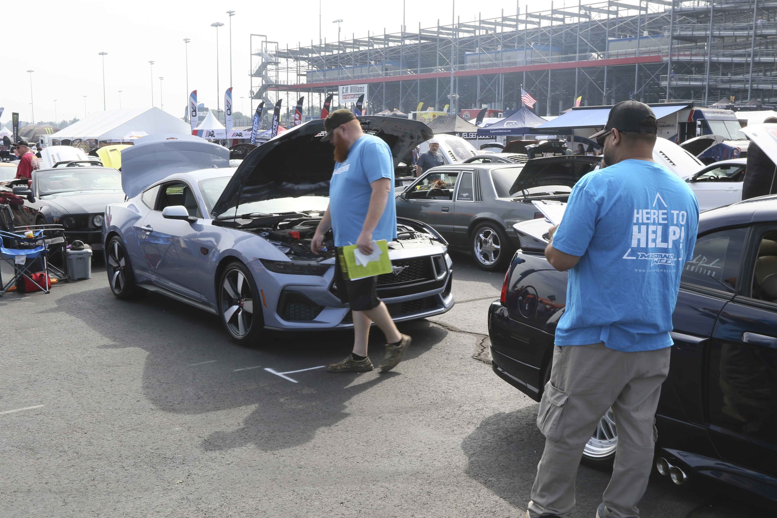 Attendees inspecting a silver Ford Mustang at Mustang Week event in Charlotte 2026.