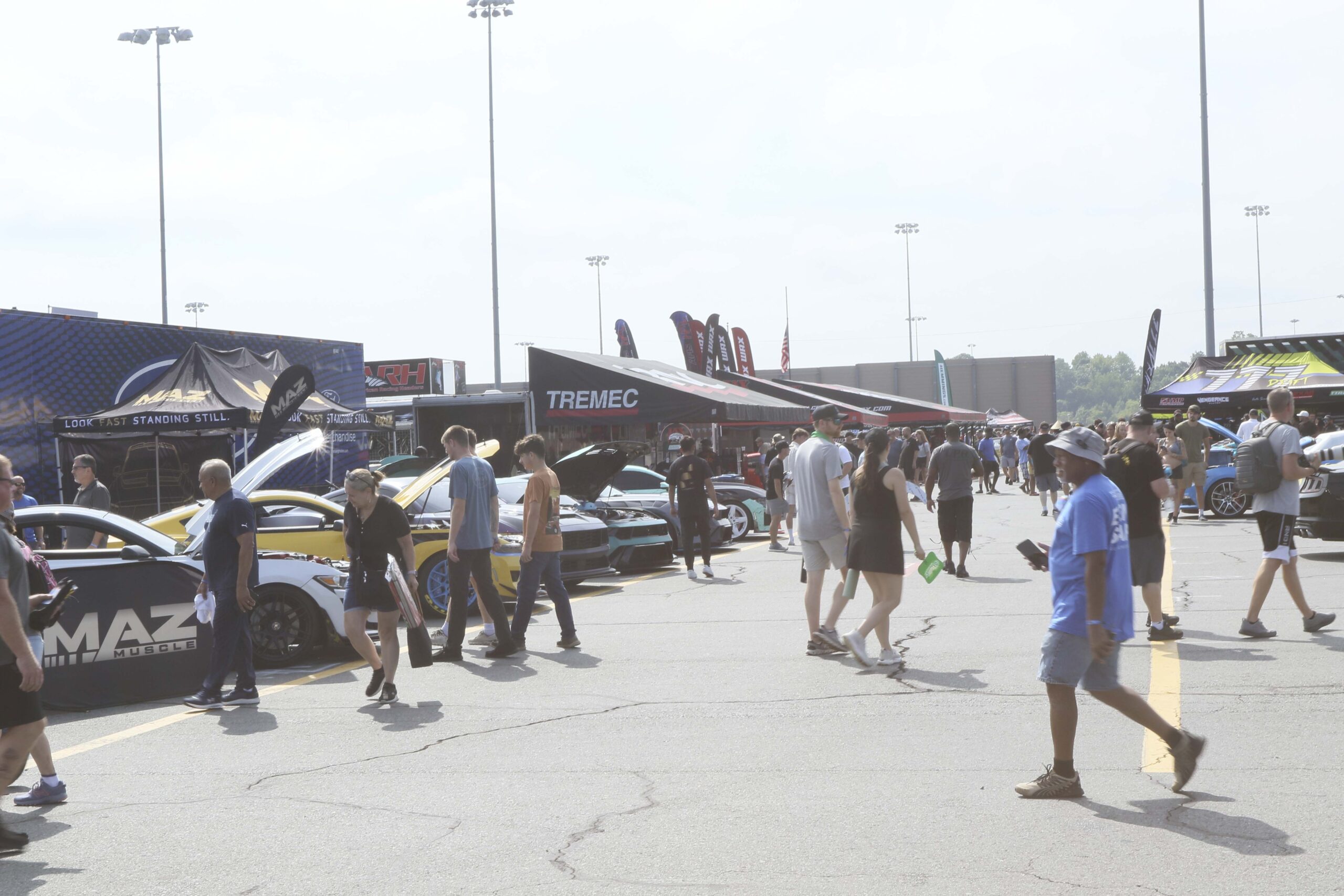 Crowd at Mustang Week car show in Charlotte with classic and modern Mustangs.