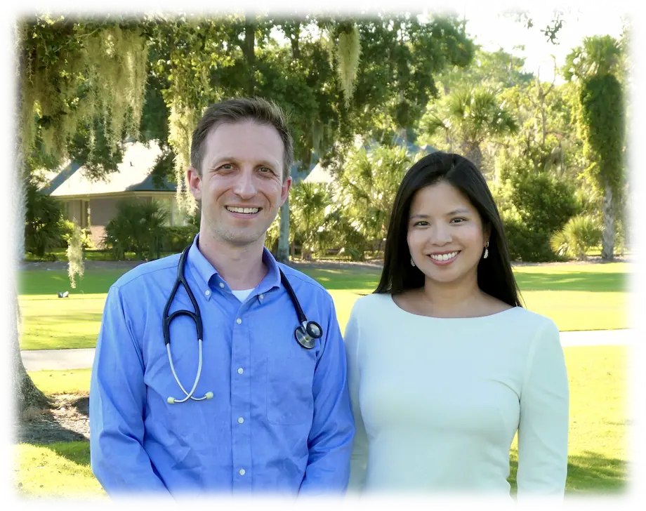 Dr. Kyle Mikals and Dr. Samantha Mikals standing wearing their white coats smiling