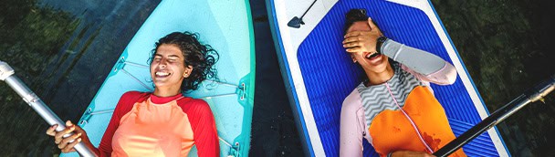 Two women enjoying paddleboarding, highlighting CC Rewards tiered spend.