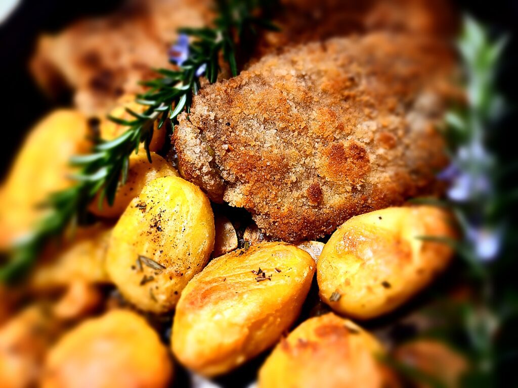 venison schnitzel with roasted potatoes and rosemary sprigs