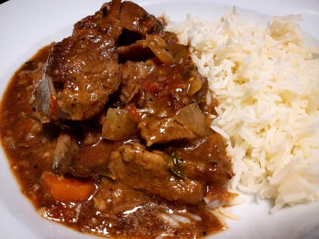 Venison stew and white steamed rice served on a white plate