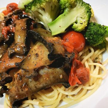 Paua sauteed with cherry tomatoes and steamed broccoli served on top of spaghetthi