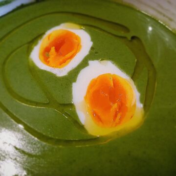 Nettles soup with egg halves on top and drizzle of olive oil