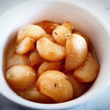 confit garlic cloves in a white ramekin