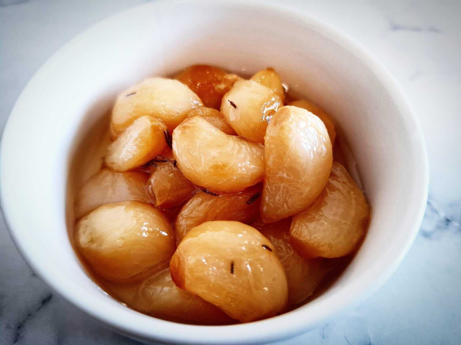 confit garlic cloves in a white ramekin