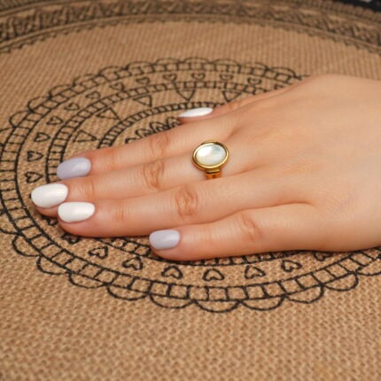 18k-gold-plated-ring-handheld.jpg" alt="Hand holding the 18K Gold Plated Ring showcasing its smooth oval shell centerpiece and shiny gold plating