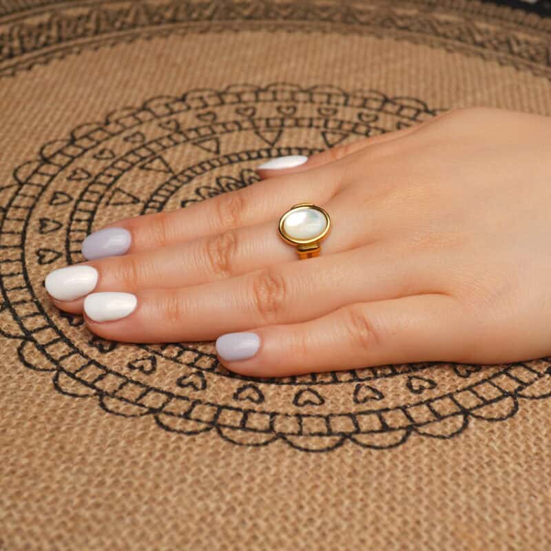 18k-gold-plated-ring-handheld.jpg" alt="Hand holding the 18K Gold Plated Ring showcasing its smooth oval shell centerpiece and shiny gold plating