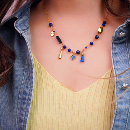 "Wearing Lapis Lazuli charm necklace, with a vibrant blue tassel and gold pendant details enhancing the outfit."