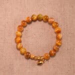 Citrine and Tiger Eye bracelet with 18K gold charm on white background