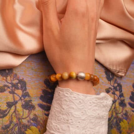 Person wearing Tiger Eye wealth bracelet on wrist with casual outfit