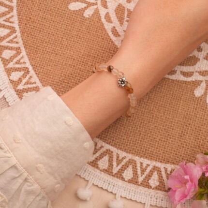 Model wearing gemstone bracelet, glowing with light and elegance