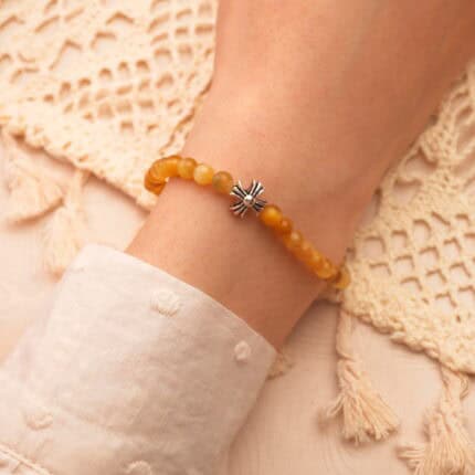 Minimalist wrist shot of the bracelet, styled with earth-tone clothing