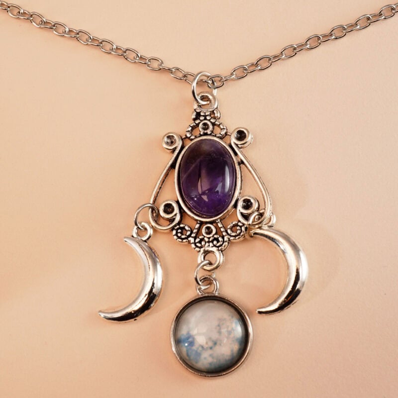 Close-up of crescent moon-shaped amethyst pendant with polished finish