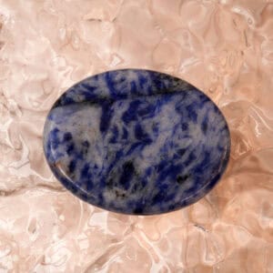 Polished blue apatite worry stone on a neutral background