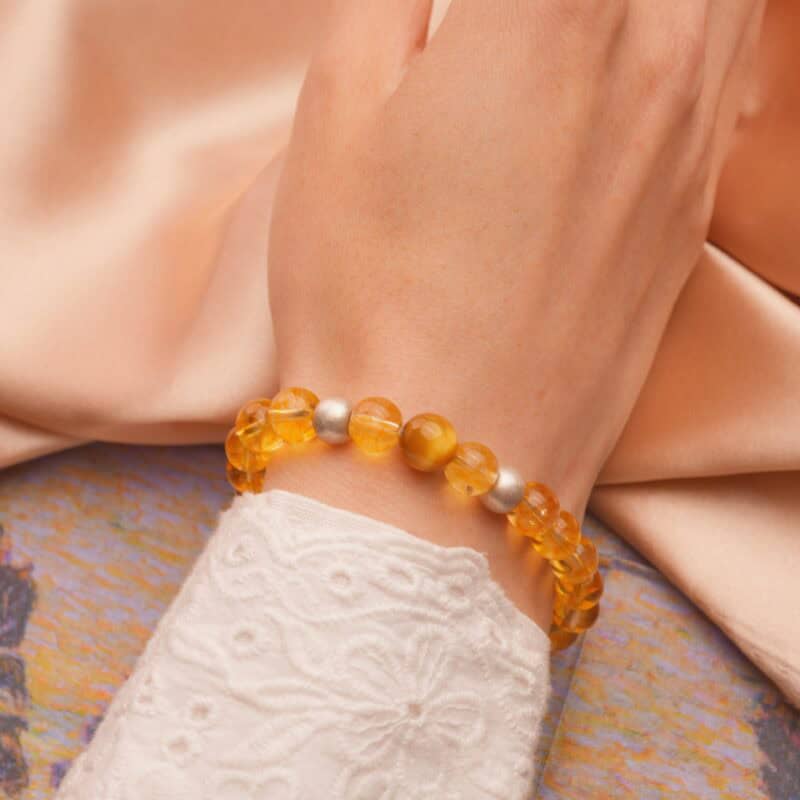Grounding Tiger Eye & Yellow Azeztulite bracelet worn on wrist in sunlight