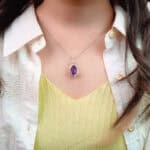 Model wearing the amethyst necklace near heart or collarbone area
