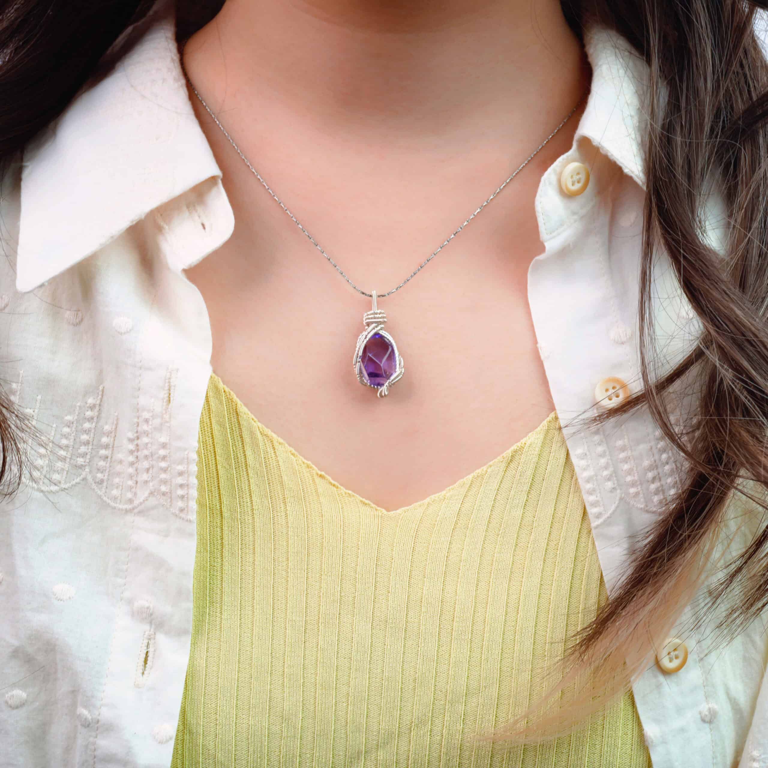 Model wearing the amethyst necklace near heart or collarbone area