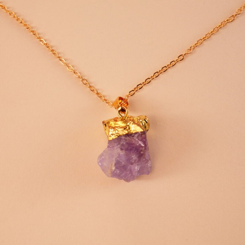 Close-up of natural amethyst crystal pendant with polished finish