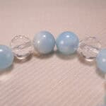Close-up of Aquamarine and Clear Quartz Beads with Oxidized Flower Charm