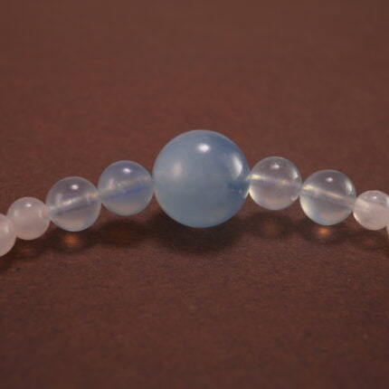 Close-up of Aquamarine Beads, Chalcedony Stones, and Silver Bow Charm