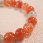 Close-up of 8mm rutile quartz beads with golden threads and heart motif