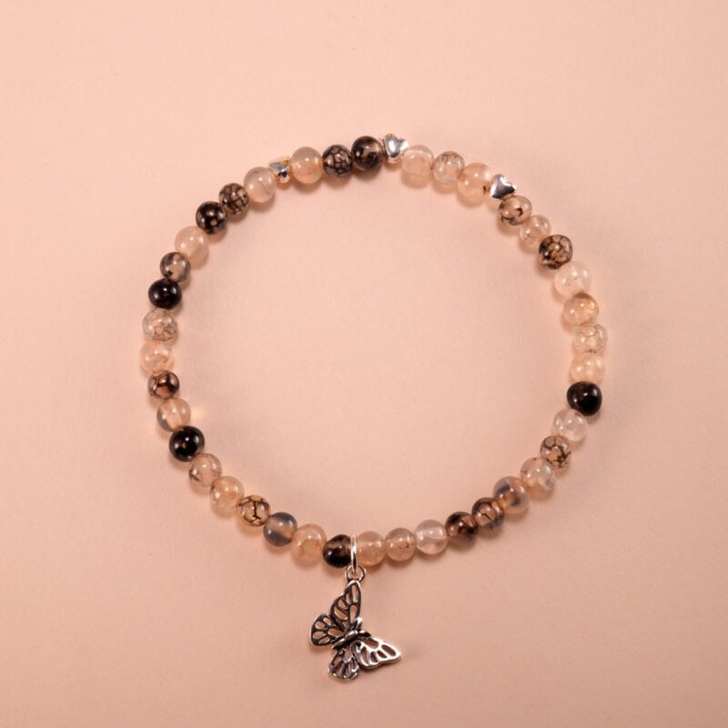 Black and white chalcedony bracelet arranged in a neat circle on a neutral background