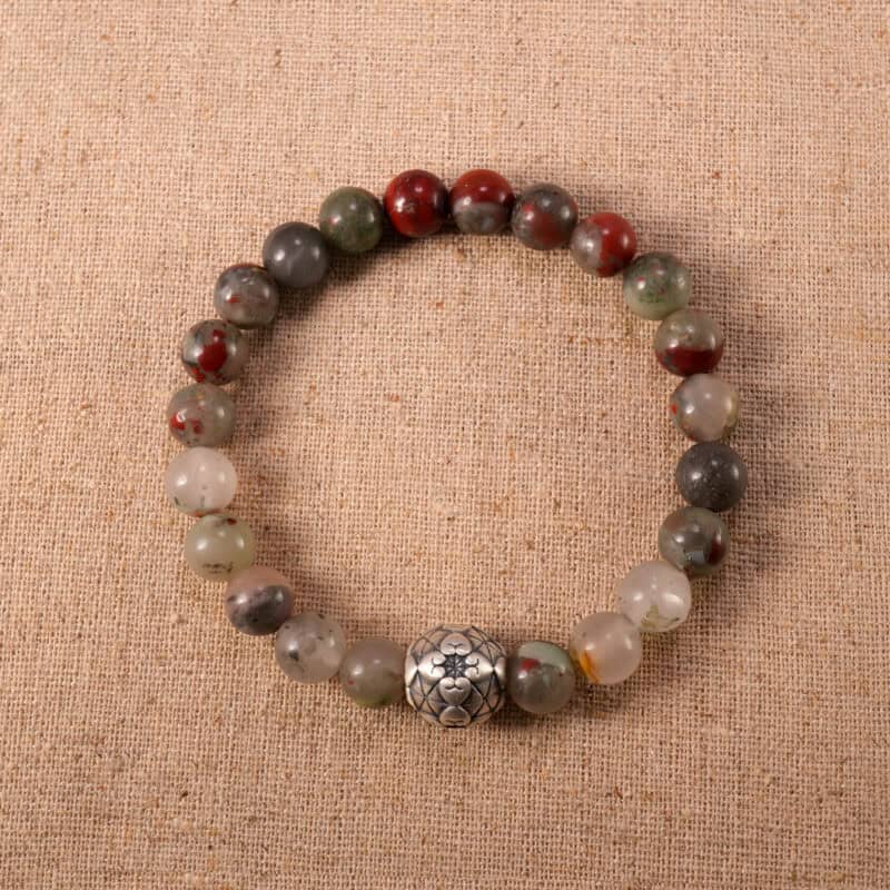 Natural Bloodstone bracelet neatly coiled on a neutral background, highlighting its deep green and red tones