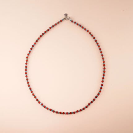 Handmade blue apatite and red agate bead necklace displayed on light background