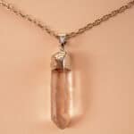 Close-up of transparent quartz point with natural inclusions and handmade wrapping