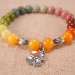 Close-up of flower charm on beaded bracelet, showcasing intricate craftsmanship