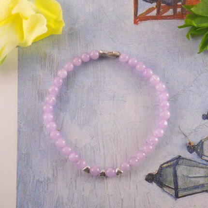Amethyst bracelet placed beside a lavender candle and journal, evoking a calming bedtime ritual