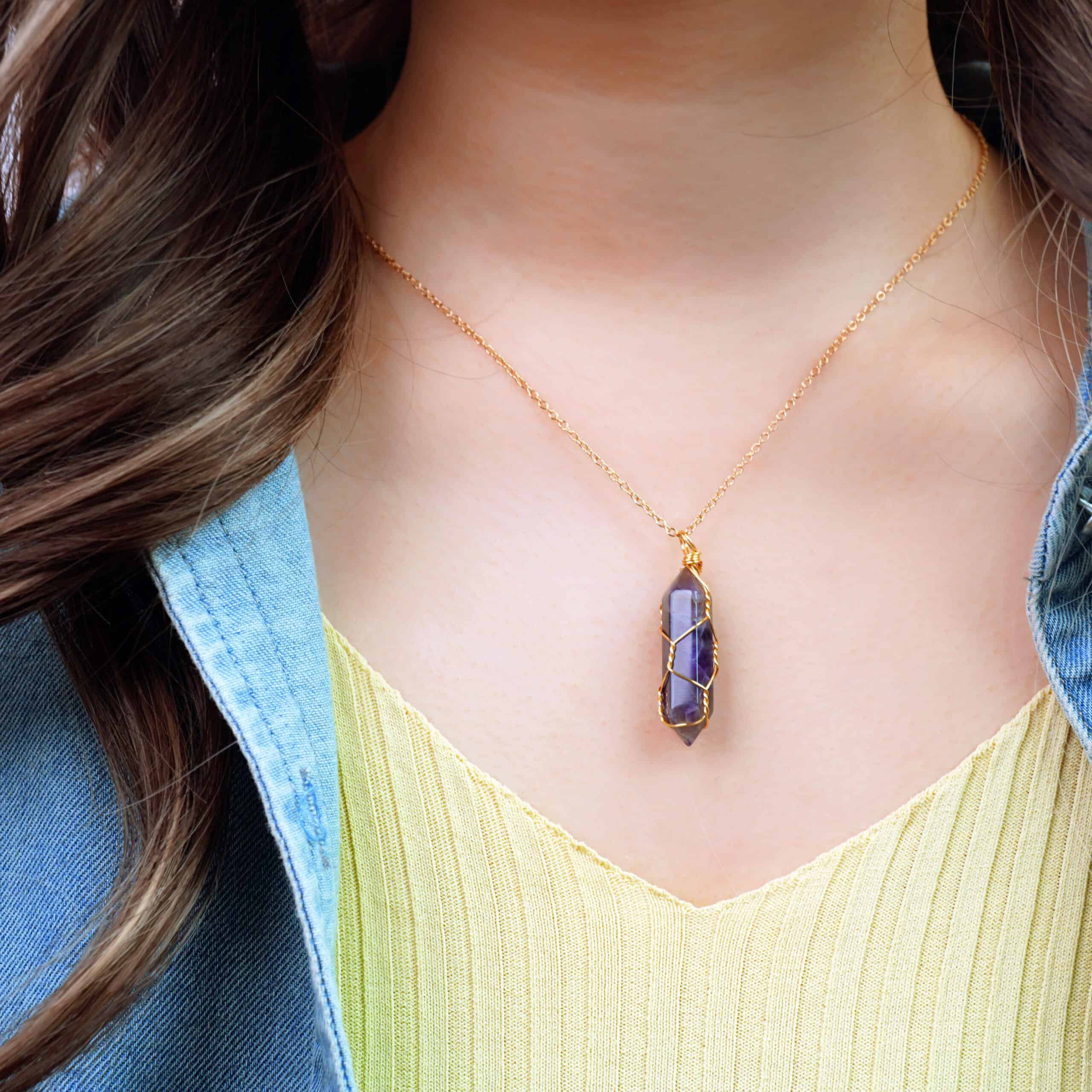 Model wearing the amethyst point pendant, resting just below the collarbone