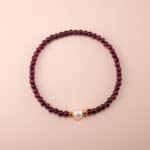 Garnet and pearl bracelet on white background