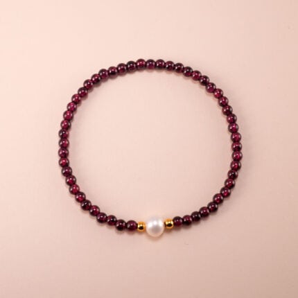 Garnet and pearl bracelet on white background