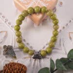 Green Alashan Stone Bracelet on linen cloth with green leaves nearby – Calm and natural vibe for healing and vitality