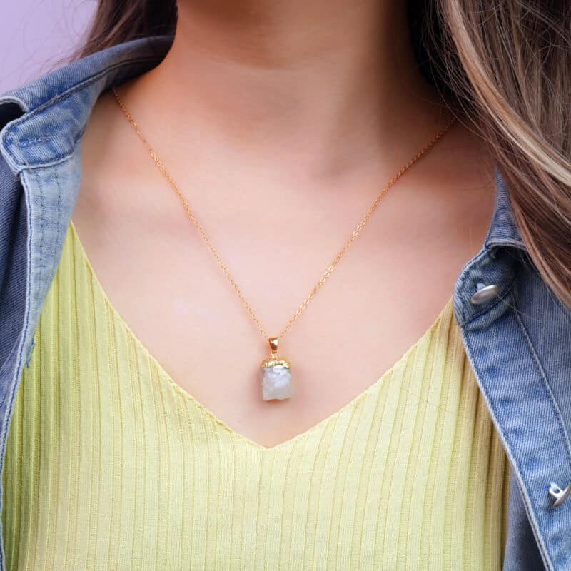 Model wearing green fluorite pendant necklace near heart or throat area