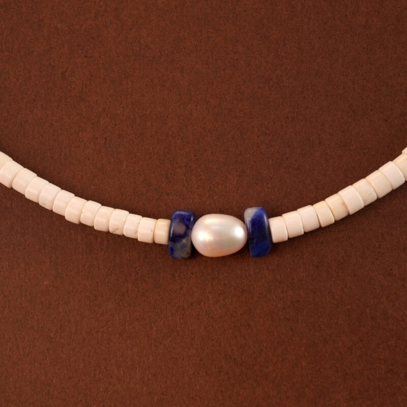 Close-up of round pearls, deep blue lapis, and translucent chalcedony beads