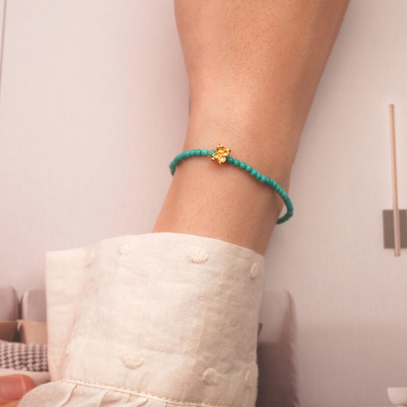 Turquoise beaded bracelet worn on wrist, casual outfit